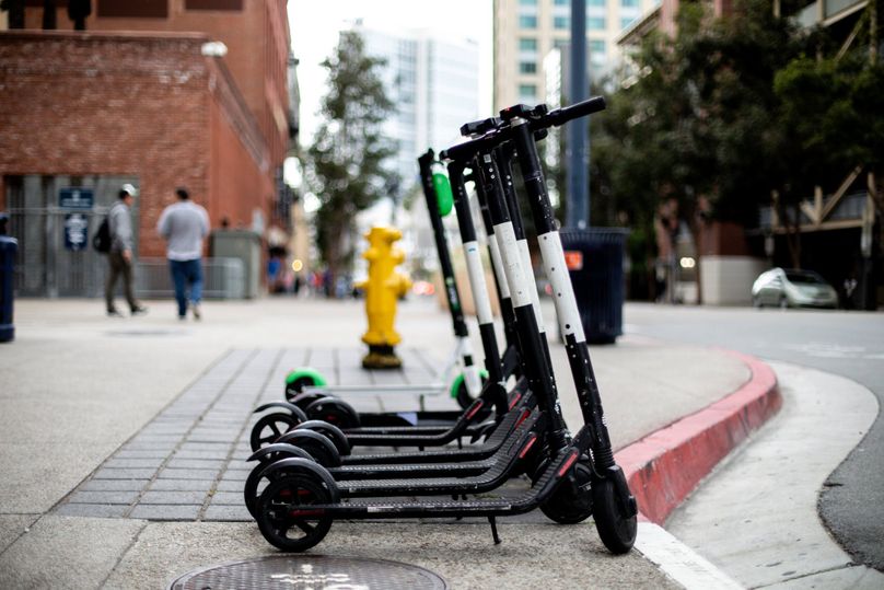 E-Scooter stehen geparkt am Straßenrand